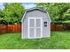 Well-maintained shed in a spacious backyard with a wooden fence and lush greenery at 10310 Foxwood W Dr, Carmel, IN 46280
