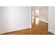 Bright hallway with hardwood floors, white walls, closet doors, and a view into another room at 1041 Lincoln Park E Dr, Greenwood, IN 46142