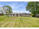 Well-maintained backyard shows spacious lawn, stone ranch home and mature trees at 10456 N State Rd 267, Brownsburg, IN 46112