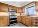 Well-lit kitchen with wood cabinets, stainless steel appliances, and modern fixtures at 10456 N State Rd 267, Brownsburg, IN 46112