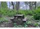 A rustic picnic table nestled within the peaceful tree canopy, offering a serene outdoor retreat at 12253 Bedrock Ct, Fishers, IN 46037