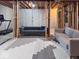 This unfinished basement features exposed ceiling, modern sofas, and patterned rug at 12253 Bedrock Ct, Fishers, IN 46037