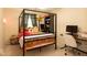 A bedroom featuring natural light, a black canopy bed and a desk with computer setup at 12253 Bedrock Ct, Fishers, IN 46037
