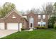 Beautiful brick home with a three-car garage, arched entryway, and neatly landscaped front yard at 12253 Bedrock Ct, Fishers, IN 46037