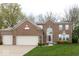 Lovely brick home featuring an attached three-car garage, mature landscaping, and welcoming entrance at 12253 Bedrock Ct, Fishers, IN 46037