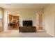 View of a media room leading to a sunny kitchen with wooden cabinets and modern appliances at 12253 Bedrock Ct, Fishers, IN 46037