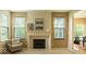 Bright living room featuring a fireplace with white mantel, neutral walls, and large windows at 12253 Bedrock Ct, Fishers, IN 46037