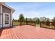 Red stained back deck with wooden railings provides ample outdoor space and lush landscaping at 12722 Moonseed Dr, Carmel, IN 46032