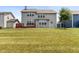 View of the rear exterior with a red wood deck, showing the home's spacious backyard with a detached garage at 12722 Moonseed Dr, Carmel, IN 46032