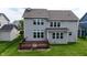Backyard view of home with a wood deck, green lawn, and multiple windows showcasing a sunlit interior at 12722 Moonseed Dr, Carmel, IN 46032
