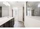 Bright bathroom with double vanity, large mirror, and glass enclosed shower with stone tile surround at 12722 Moonseed Dr, Carmel, IN 46032