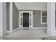 Front porch view with stone flooring, painted door, and side windows at 12722 Moonseed Dr, Carmel, IN 46032
