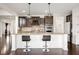 Spacious kitchen island with bar seating, dark cabinetry, and modern pendant lighting at 12722 Moonseed Dr, Carmel, IN 46032