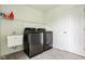 Well-equipped laundry room with modern washer and dryer, utility sink and storage shelf at 12722 Moonseed Dr, Carmel, IN 46032