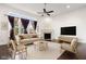Bright living room with modern decor, fireplace, ceiling fan and large windows at 12722 Moonseed Dr, Carmel, IN 46032