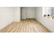 Spacious basement featuring wood-look flooring, white walls, a window, and a door at 1337 N Concord St, Indianapolis, IN 46222