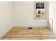 An empty room featuring hardwood floors, white walls, and a window for natural light at 1337 N Concord St, Indianapolis, IN 46222
