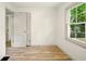 A well-lit room with hardwood floors and a window for natural light and open door at 1337 N Concord St, Indianapolis, IN 46222