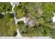 An aerial view reveals a well-maintained home with mature trees, a long driveway, and lush greenery at 13765 Howe Rd, Fishers, IN 46038