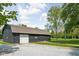 A spacious barn features a white garage door, contrasting nicely against its dark exterior and the surrounding gravel driveway at 13765 Howe Rd, Fishers, IN 46038