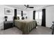 Comfortable bedroom featuring a queen bed, black curtains, and neutral decor with carpeted floors at 13765 Howe Rd, Fishers, IN 46038