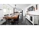 Dining area featuring a long wooden table, black chairs, and stylish decorative cabinets, perfect for hosting gatherings at 13765 Howe Rd, Fishers, IN 46038