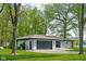 Charming single-story home with a gray garage door, white painted brick, surrounded by mature trees at 13765 Howe Rd, Fishers, IN 46038