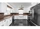 Well-lit kitchen with white cabinetry, copper-trimmed counters and backsplash, and black appliances and tile flooring at 13765 Howe Rd, Fishers, IN 46038