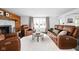 Bright living room featuring leather furniture, a fireplace and a large window that fills the space with natural light at 13765 Howe Rd, Fishers, IN 46038