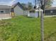 Spacious backyard featuring lush green grass and a shed with the home's exterior in the background at 1527 N C N St, Elwood, IN 46036