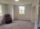 Carpeted bedroom with built-in storage cabinets, a window, and a recliner chair at 1527 N C N St, Elwood, IN 46036