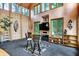 Bright dining room with a vaulted wood ceiling and walls of windows overlooking the property at 1530 E 75Th St, Indianapolis, IN 46240