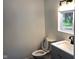 Modern bathroom with gray vanity, sink, toilet and window at 1545 Finley Ave, Indianapolis, IN 46203