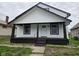 Charming home with a covered front porch, black trim, and white siding at 1545 Finley Ave, Indianapolis, IN 46203