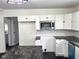 Well-lit kitchen featuring white subway tiles, white cabinetry, and stainless steel microwave at 1545 Finley Ave, Indianapolis, IN 46203