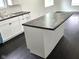 Modern kitchen with an island featuring a dark countertop and sleek white cabinetry at 1545 Finley Ave, Indianapolis, IN 46203