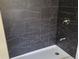 Modern shower with striking black marble tile and a sleek chrome faucet at 1545 Finley Ave, Indianapolis, IN 46203