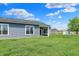 Back of a well-maintained home with a covered patio and a lush green lawn under a bright blue sky at 1639 Clover Crossing Dr, Greenfield, IN 46140
