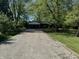 View of the home from the driveway surrounded by lush greenery at 1725 E 100 S, Lebanon, IN 46052