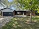 Charming brick ranch-style home with an attached garage and a cozy front porch, all surrounded by mature trees at 1725 E 100 S, Lebanon, IN 46052