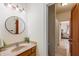 Bathroom featuring a wood vanity and a decorative round mirror at 1832 Live Oak Ct, Avon, IN 46123