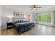 Bright bedroom featuring a metal frame bed, ceiling fan, wood floors, and large windows at 1832 Live Oak Ct, Avon, IN 46123