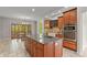 Kitchen with wood cabinets, stainless appliances, granite island with cooktop, and light fixture at 1832 Live Oak Ct, Avon, IN 46123
