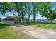 Large backyard with partial fence, mature trees, grass and gravel at 1912 Broadway St, Anderson, IN 46012