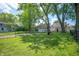 A sprawling backyard features mature trees and a partial fence at 1912 Broadway St, Anderson, IN 46012