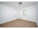 An empty bedroom offers neutral carpet, white walls, and natural light from two windows at 1912 Broadway St, Anderson, IN 46012
