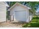 A detached one car garage with white door and a gravel driveway at 1912 Broadway St, Anderson, IN 46012