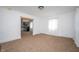 Open concept living space with neutral carpet and a view into the updated kitchen area at 1912 Broadway St, Anderson, IN 46012