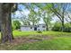 The backyard features mature trees, green lawn, and white vinyl siding at 1944 Galeston Ct, Indianapolis, IN 46229