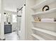 Bright bathroom featuring a gray vanity and open shelves with decor items, offering a blend of style and practical storage at 1944 Galeston Ct, Indianapolis, IN 46229